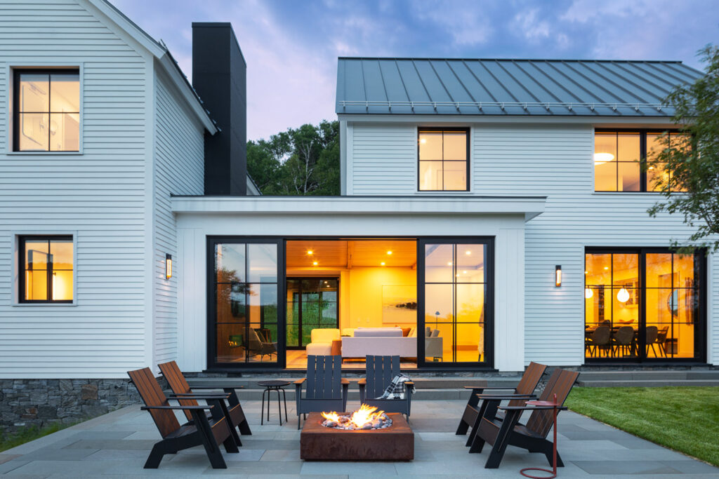 Luxury house construction with modern exterior with white siding and open concept windows.