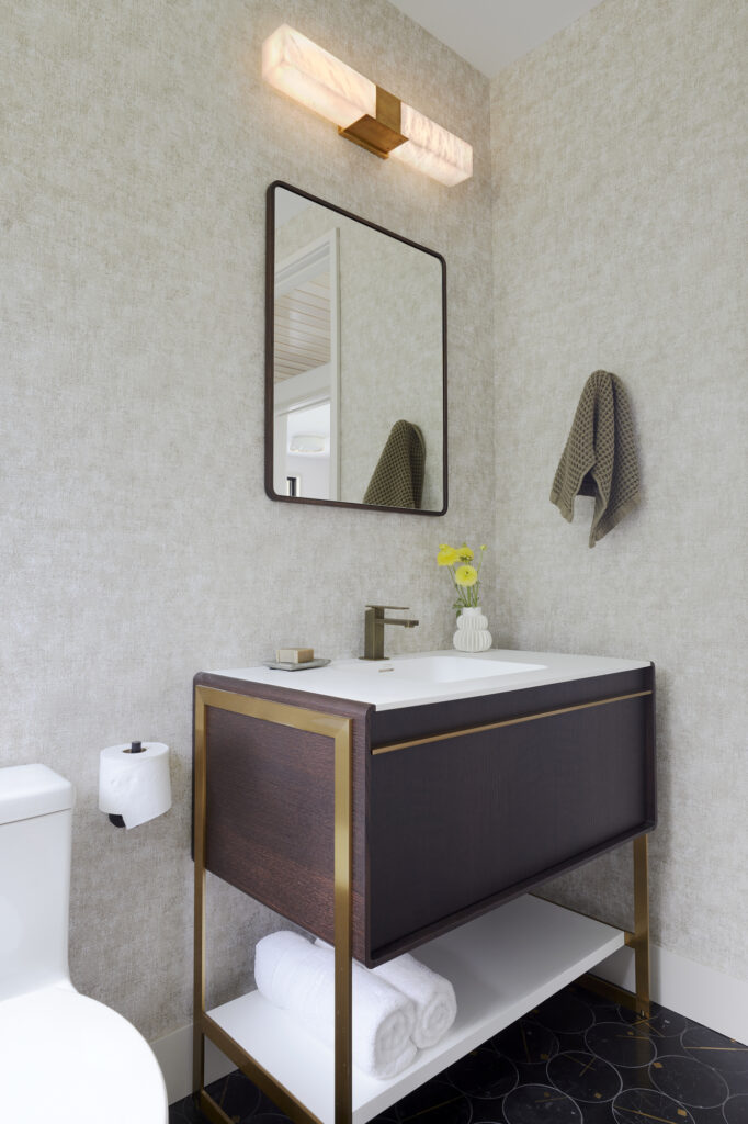 Neutral grey minimalist wallpaper design in a powder room. Renovation done by Silver Maple in Vermont
