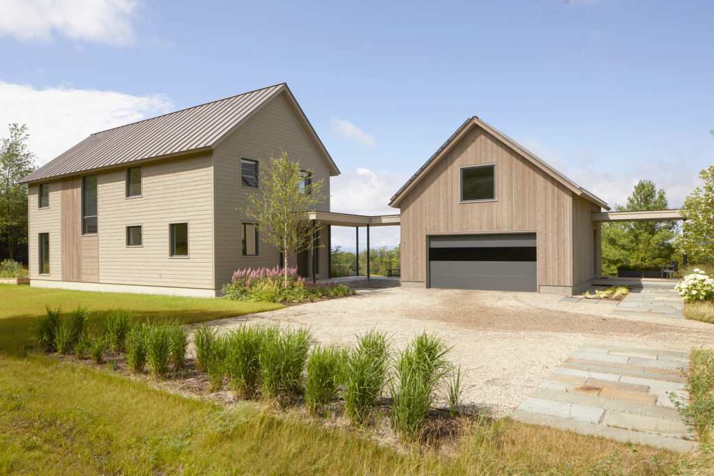 modern mountain house nestled between trees with Vermont mountain views in the back. Luxury house construction example.