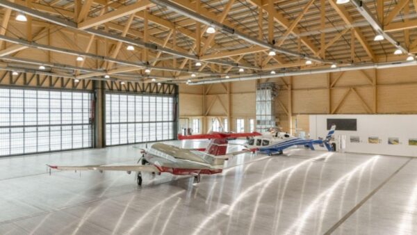 Aircraft hangar made of wood, housing multiple airplanes.