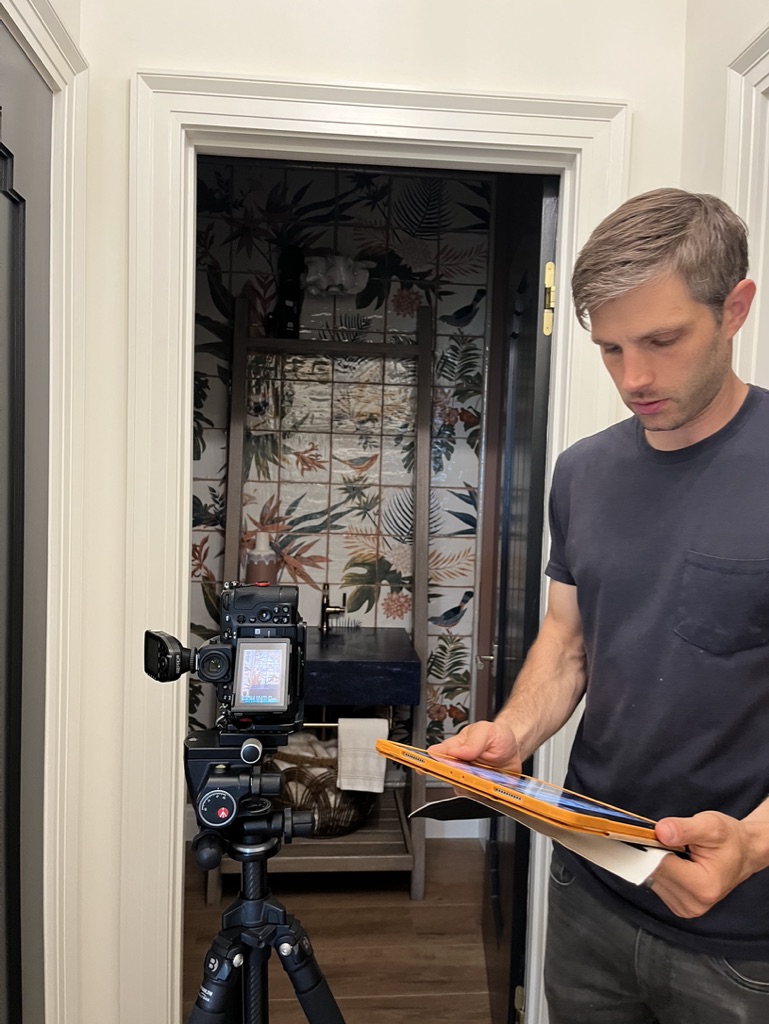 A behind the scenes look at a professional photographer capturing interior construction details in a custom home renovation by Silver Maple. Photographer, Ryan Bent, is looking at images on his iPad to determine necessary adjustments.