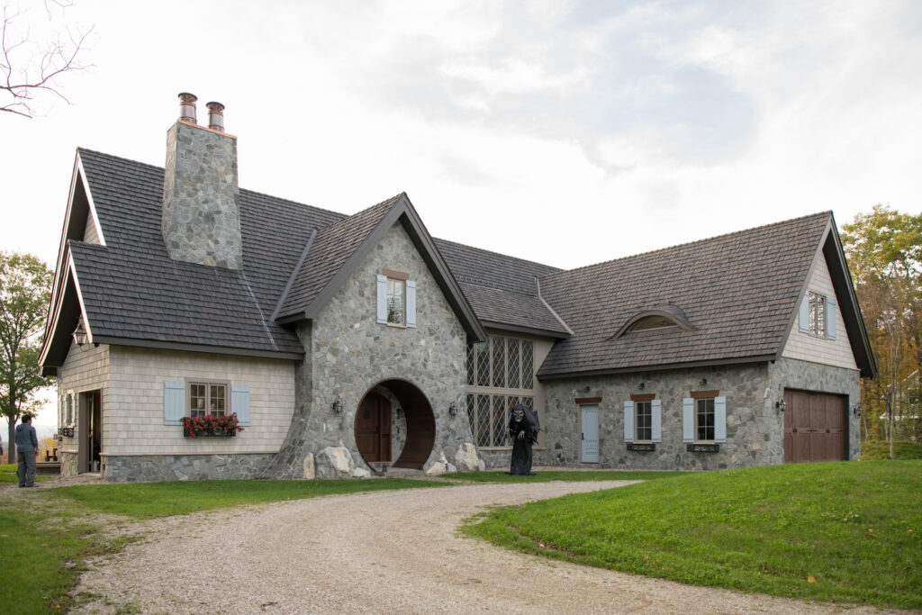 Scouting image of a whimsical stone house against a lush Vermont landscape